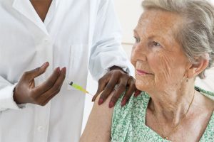 doctor giving elder woman vaccine